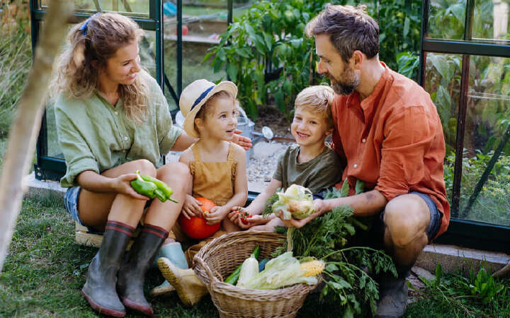 familie sitzt im garten erntet gemuese 800x500